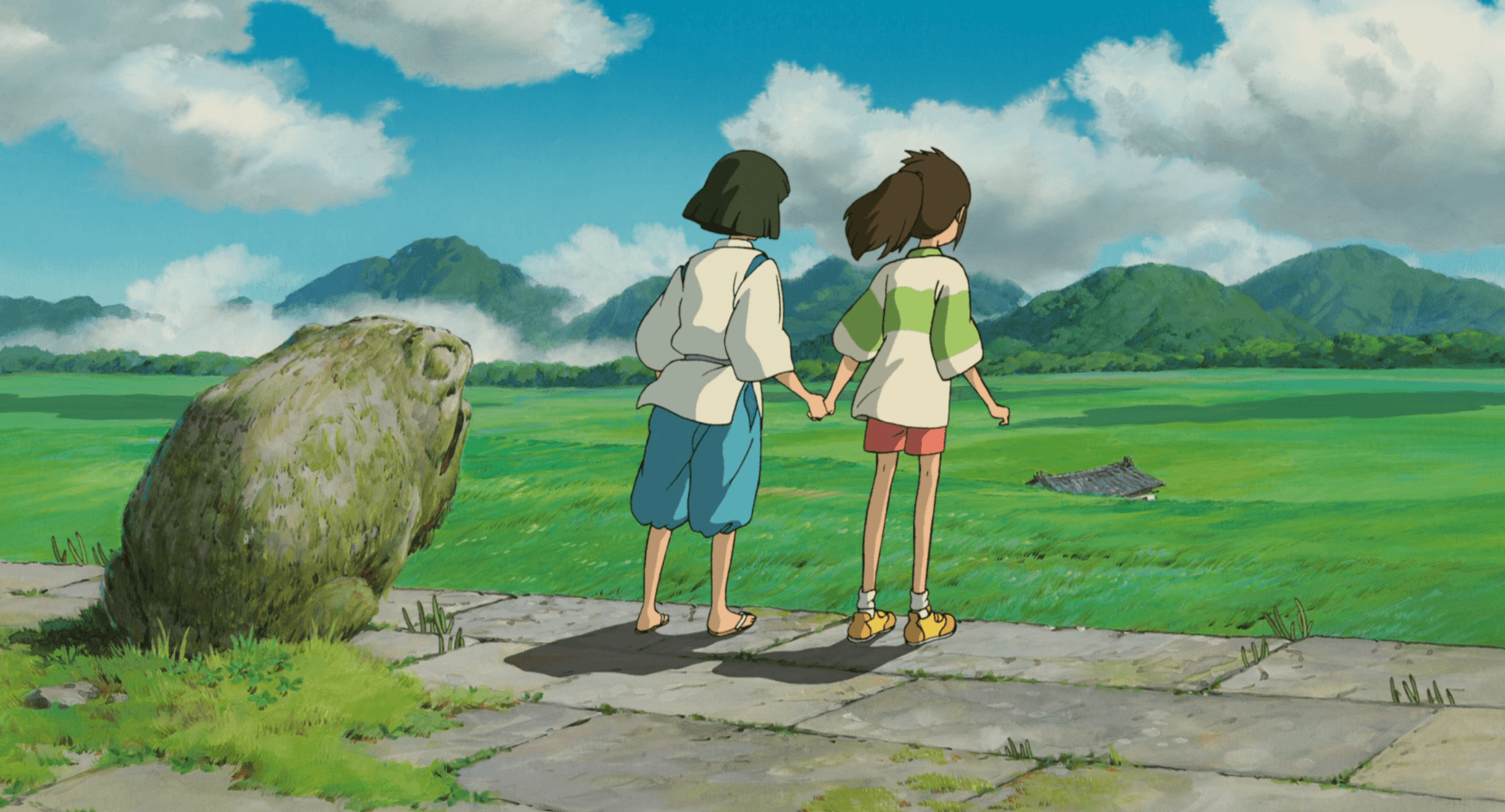 Haku and Chihiro facing a lush valley